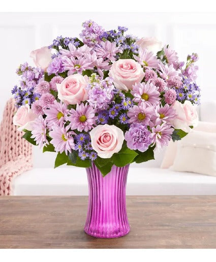 Pink roses with purple stock purple fillers in a lavender vase