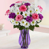 Pink roses with white daisies and purple carnations in a lavender vase