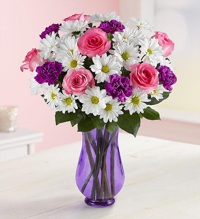 Pink roses with white daisies and purple carnations in a lavender vase